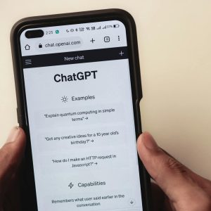 Webpage of ChatGPT, a prototype AI chatbot, is seen on the website of OpenAI, on a smartphone. Examples, capabilities, and limitations are shown.